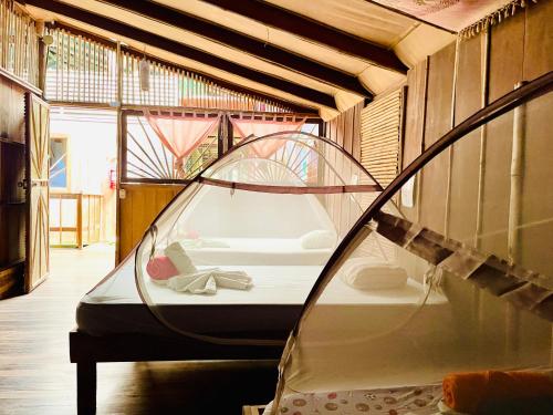 una camera con un letto in una casa di vetro di Cascada Verde Hostel a Uvita