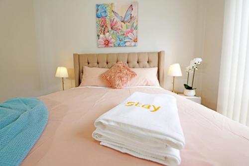 a bed with a pile of white towels on it at Spacious 5BR House in Hallam near Bunjil Place in Hallam