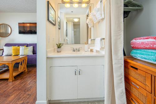 een badkamer met een wastafel en een spiegel bij @ Marbella Lane - Marina Studio near the beach in Honolulu