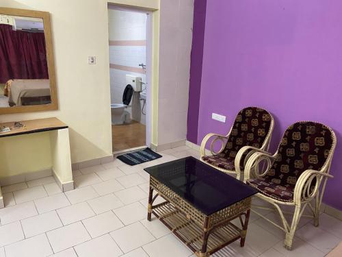 La salle de bains est pourvue de 2 chaises, d'une table et d'un miroir. dans l'établissement Hotel Samudra Tara, à Kovalam