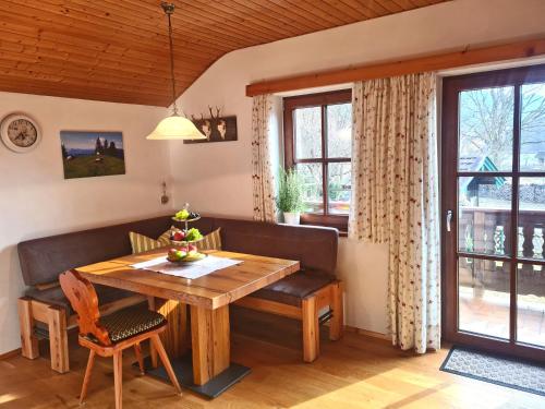 uma sala de jantar com uma mesa de madeira e um banco em Ferienwohnungen Hamberger em Sachrang