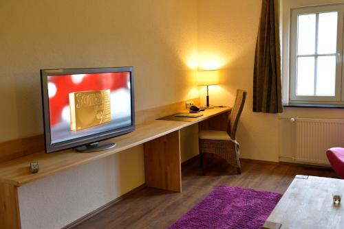a television sitting on a desk in a room at Land- und Golfhotel Alte Fliegerschule in Eisenach