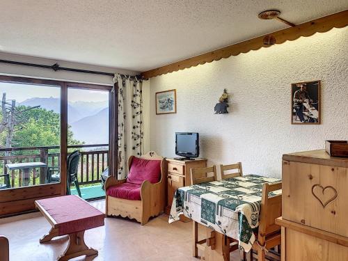 une chambre avec un lit et une télévision et un balcon dans l'établissement Cocon 2 pièces + studio au centre de Combloux avec parking - FR-1-560-74, à Combloux