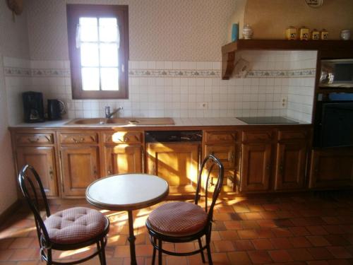 a kitchen with a table and chairs and a sink at Gîte spacieux avec billard, cheminée & terrasse, près de la forêt de Bercé, Wi-Fi & activités nature - FR-1-410-337 in Thoiré-sur-Dinan