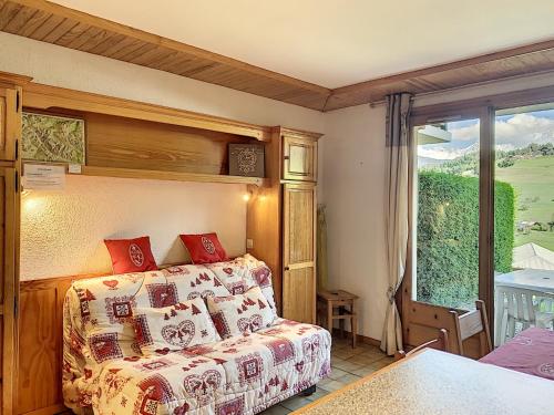 a bedroom with a bed and a large window at Studio cosy pour 3 avec terrasse, parking et casier à ski à Combloux - FR-1-560-77 in Combloux