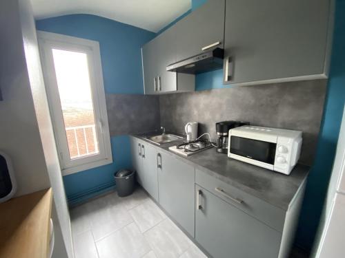 une petite cuisine avec un four micro-ondes sur un comptoir dans l'établissement Studio central avec Wi-Fi proche des Thermes de La Roche-Posay - FR-1-541-82, à La Roche-Posay