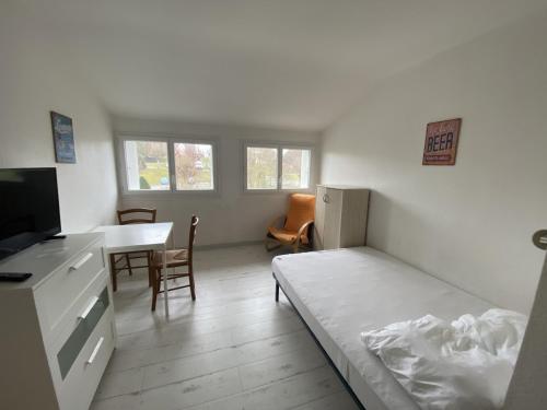 une chambre avec un lit, un bureau et une table dans l'établissement Studio cosy en cœur de La Roche-Posay, proche Thermes, Wi-Fi, laverie, tout équipé - FR-1-541-84, à La Roche-Posay
