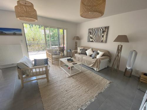 un salon avec un canapé et une table dans l'établissement Charmant appartement pour 6 en centre-ville d'Arcachon avec terrasse, parking et WiFi - FR-1-474-174, à Arcachon
