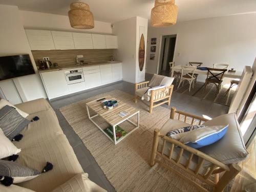 un salon avec des canapés et une table ainsi qu'une cuisine dans l'établissement Charmant appartement pour 6 en centre-ville d'Arcachon avec terrasse, parking et WiFi - FR-1-474-174, à Arcachon