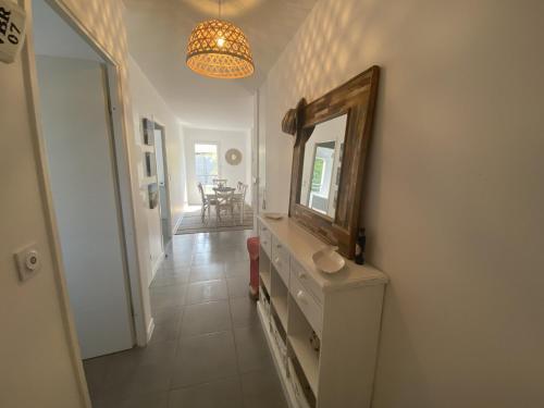 - un couloir avec un miroir et une commode dans la chambre dans l'établissement Charmant appartement pour 6 en centre-ville d'Arcachon avec terrasse, parking et WiFi - FR-1-474-174, à Arcachon