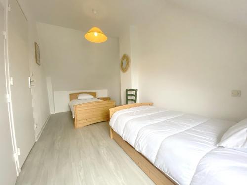 a white bedroom with two beds and a desk at Maison récente 6 pers., proche plage, jardin paisible, activités variées - FR-1-639-3 in Saint-Gildas-de-Rhuys