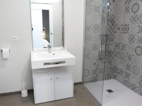 a bathroom with a white sink and a shower at Appartement PMR avec balcon, piscine, parking et plage à La Tranche-sur-Mer - FR-1-194-229 in La Tranche-sur-Mer