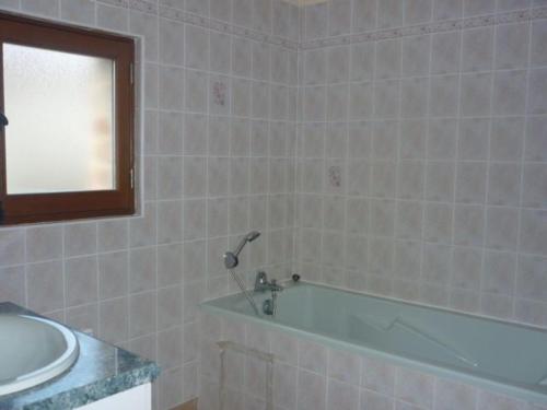 a bathroom with a bath tub and a sink at Ancien corps de ferme restauré avec jardin clos, proche A11, 3 chambres, barbecue, calme garanti - FR-1-410-343 in Le Bailleul