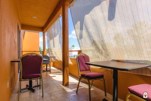 a balcony with chairs and a table and a window at Coyote South in Santa Fe