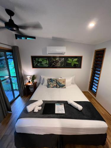 a bedroom with a large bed with two towels on it at Safari Lodge in Cape Tribulation