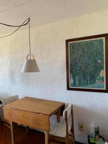 a dining room table with a painting on the wall at Balcones del Cabito 008 in La Paloma
