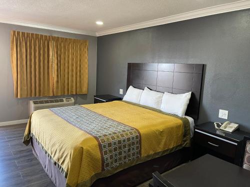 Habitación de hotel con cama con manta amarilla en El Segundo Inn en Hawthorne