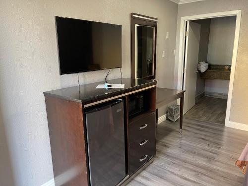 a living room with a flat screen tv on a wall at El Segundo Inn in Hawthorne