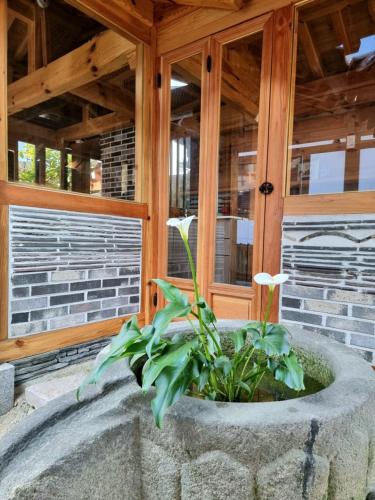 a stone planter with flowers in front of a building at HanokInn in Gyeongju
