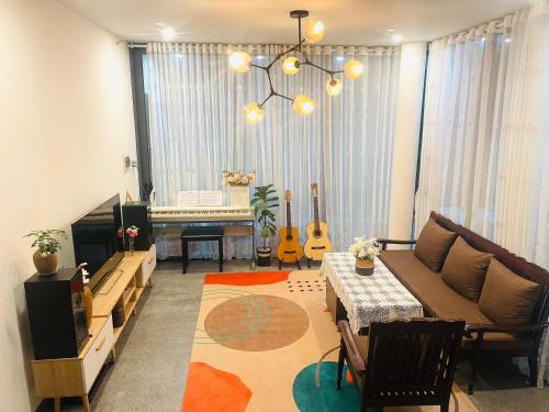 a living room with a couch and a piano at HOMEY Homestay Hue 