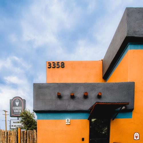 an orange building with a sign on the side of it at Coyote South in Santa Fe