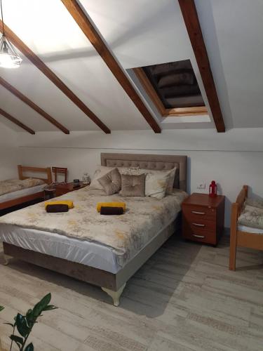 Fruškogorski Đeram في Grgeteg: غرفة نوم بسرير كبير وسقف خشبي