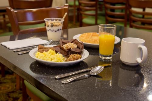 a table with a plate of breakfast food and orange juice at Country Inn & Suites by Radisson, Macedonia, OH in Macedonia