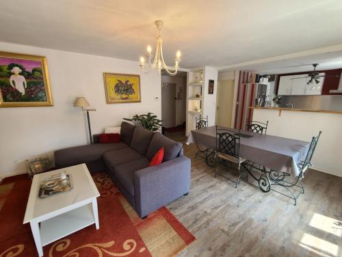 un salon avec un canapé et une table dans l'établissement Appartement Confortable à Remiremont, Proche Centre et Commerces, Garage et Wifi Inclus - FR-1-589-132, à Remiremont