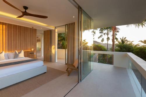 een slaapkamer met een bed en een balkon bij Villa Celadon in Mae Nam