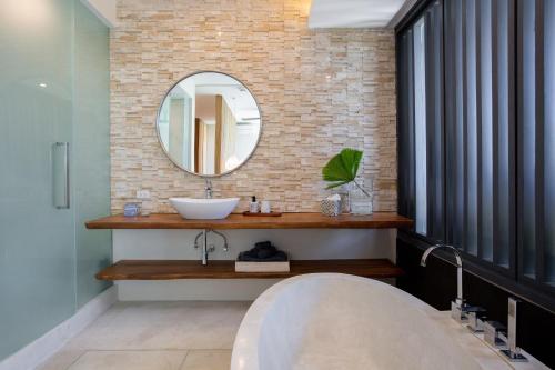 een badkamer met een wastafel en een spiegel bij Villa Celadon in Mae Nam