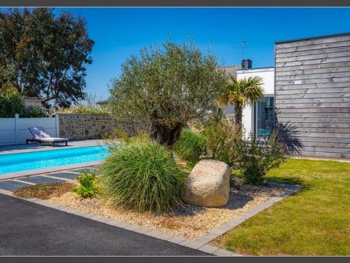 une maison avec une piscine dans une cour dans l'établissement Maison avec Piscine Chauffée, Jardin, WIFI, Proche Plages et Commodités à Erdeven - FR-1-397-53, à Erdeven