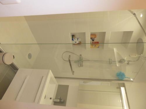 une salle de bain blanche avec une douche et un lavabo dans l'établissement Maison avec Piscine Chauffée, Jardin, WIFI, Proche Plages et Commodités à Erdeven - FR-1-397-53, à Erdeven