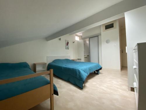 1 dormitorio con 2 camas y sábanas azules en Appartement La Roche-Posay, 2 pièces, 3 personnes - FR-1-541-72, en La Roche-Posay