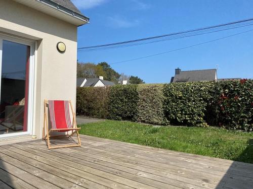 une chaise assise sur une terrasse dans une cour dans l'établissement Maison 3 pièces avec jardin, Terrasse, Wifi - Proche plages et sentiers côtiers - Erdeven - FR-1-397-55, à Erdeven