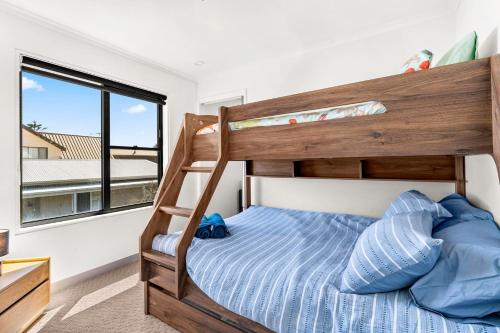 um quarto com um beliche e uma janela em Coast Leumeah em Surf Beach