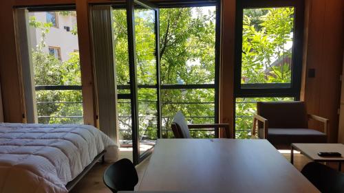 a bedroom with a bed and a large window at Apartamento 16 - Vivero 5 in San Martín de los Andes