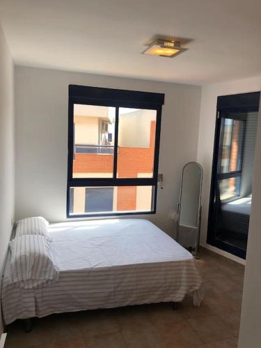 a bedroom with a bed and a large window at Adosado, wifi, playa, lugar espacioso, vacacional in Grao de Castellón