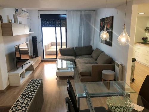 a living room with a couch and a glass table at Adosado, wifi, playa, lugar espacioso, vacacional in Grao de Castellón