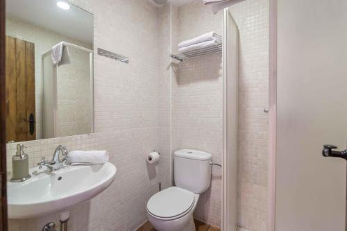 biała łazienka z toaletą i umywalką w obiekcie Hostal Yeti w mieście Sierra Nevada