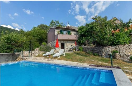 - une piscine avec 2 chaises et une maison dans l'établissement House Honey, à Lovreć