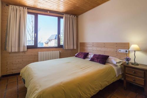 sypialnia z dużym łóżkiem i oknem w obiekcie Hostal Yeti w mieście Sierra Nevada