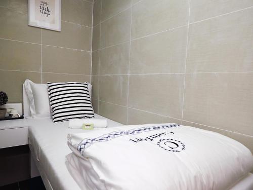 a bed in a room with a pillow on it at Joyous Guest House in Hong Kong