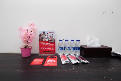 a table with bottles of water and a box of soda at RedDoorz Syariah near RS Hermina Yogyakarta in Seturan