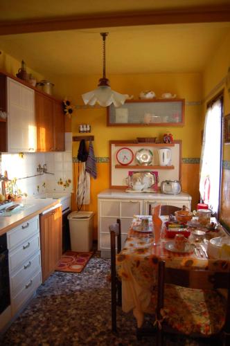 a kitchen with a table and a kitchen with yellow walls at Art B&B La Casa del Pittore in Revine Lago