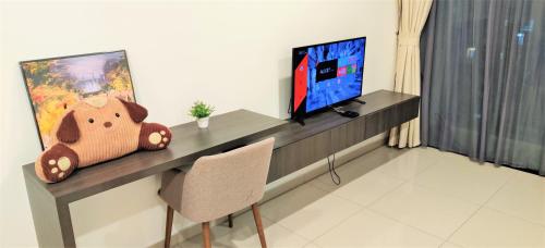 a desk with a television and a teddy bear on it at i-City【CASA IMPIAN】~Wifi/Netflix/Parking~7pax in Shah Alam