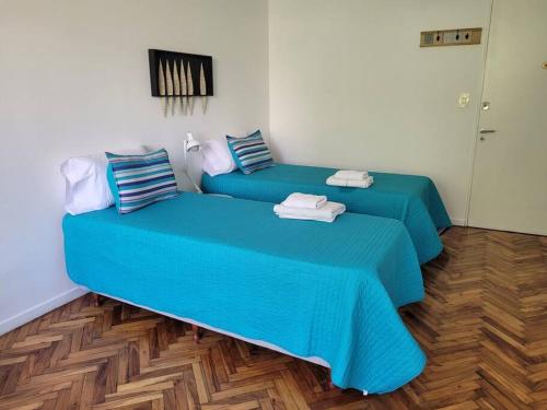 2 camas sentadas en una habitación con sábanas azules en Alto Bulnes II en Buenos Aires