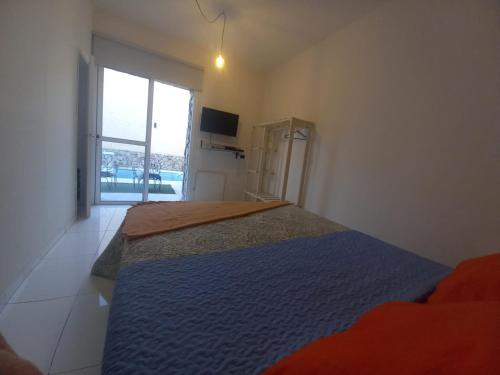 1 dormitorio con cama con colcha azul y ventana en La Faustina en Maipú
