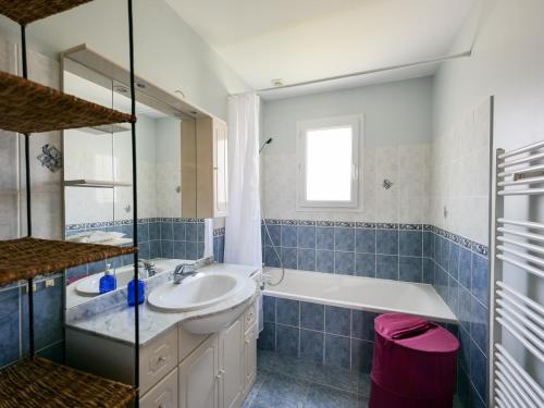 ein blau gefliestes Bad mit einem Waschbecken und einer Badewanne in der Unterkunft Maison Les Sables-d'Olonne, 4 pièces, 8 personnes - FR-1-197-500 in Les Sables-dʼOlonne