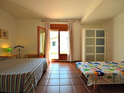 ein Schlafzimmer mit 2 Betten und einer offenen Tür in der Unterkunft Casa Sant Pere Pescador, 3 dormitorios, 6 personas - ES-89-69 in Sant Pere Pescador