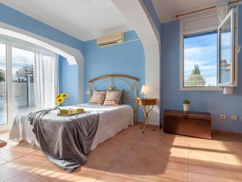 Schlafzimmer mit einem Bett mit blauen Wänden und Fenstern in der Unterkunft Casa Sant Pere Pescador, 5 dormitorios, 10 personas - ES-89-78 in Sant Pere Pescador